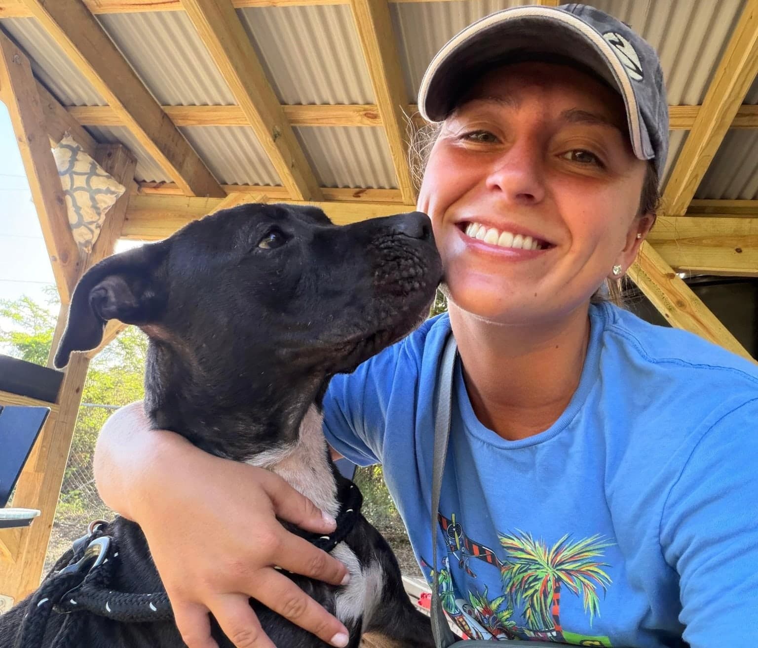 A volunteer getting a kiss from a shelter dog